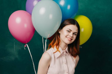 Neşeli bir kadın renkli balonlarla doğum günü eğlencesi