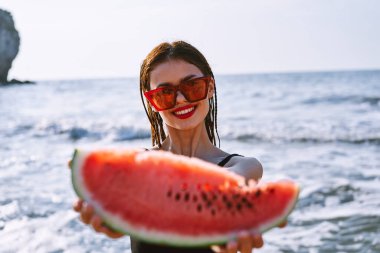 Siyah mayo giymiş neşeli güzel bir kadın karpuz moda seyahati