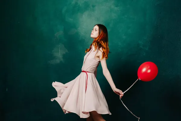 Mooie vrouw in jurk rode ballon verjaardag groene achtergrond — Stockfoto