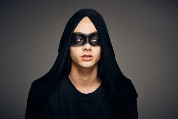 Um homem com uma máscara preta Halloween traje fantasma fundo escuro — Fotografia de Stock