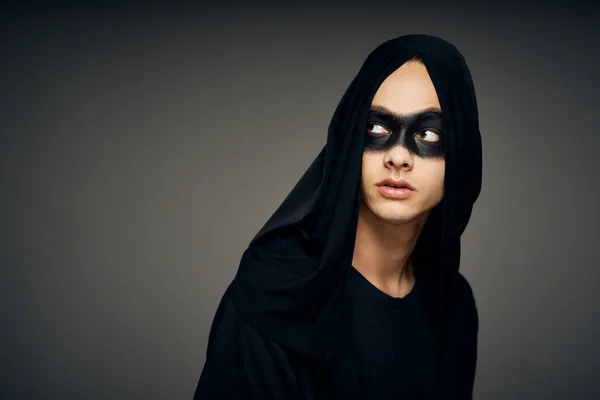 Un homme dans un masque noir costume d'Halloween fantôme fond sombre — Photo