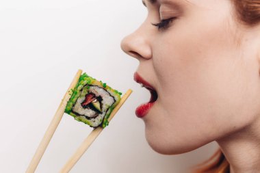 Neşeli kızıl saçlı kadın yemek çubukları suşi Japon mutfağı.