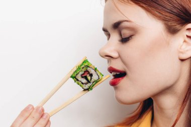 Neşeli kızıl saçlı kadın yemek çubukları suşi Japon mutfağı.