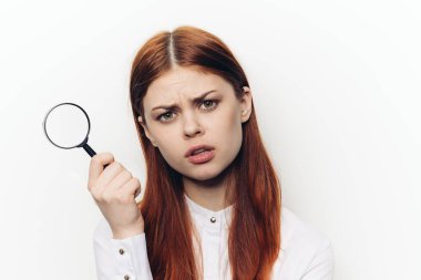 Yüzünde büyüteçle yüzünü buruşturan güzel bir kadın.