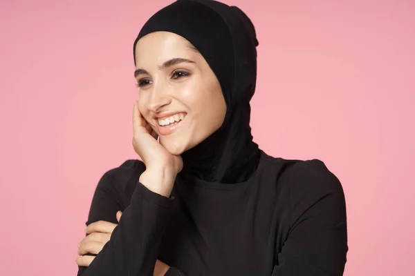 快乐的穆斯林女性黑色头巾摆出手势粉红的背景 — 图库照片