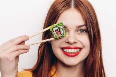 Neşeli kızıl saçlı kadın yemek çubukları suşi Japon mutfağı.
