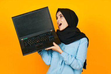 Ellerinde dizüstü bilgisayarı olan Müslüman duyguları sarı arkaplan