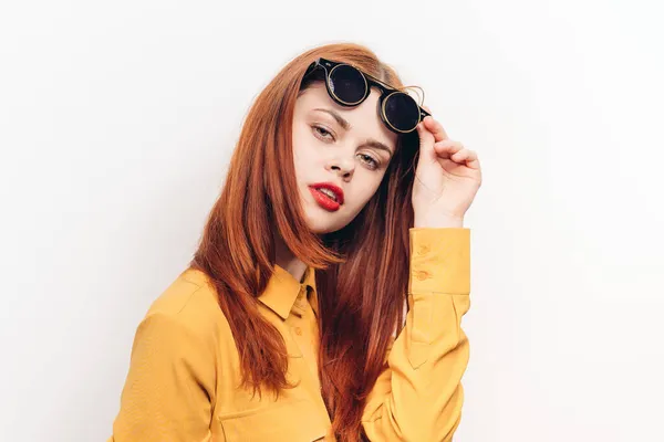 Блискуча жінка сонцезахисні окуляри червоне волосся світлий фон — стокове фото