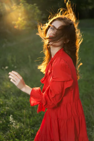 Kırmızı elbiseli kadın doğa güneşi pozu veriyor. — Stok fotoğraf