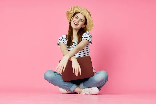 Žena s notebookem sedí na podlaze technologie internet nakupování růžové pozadí — Stock fotografie