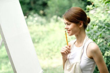 Neşeli kadın sanatçı doğa yaratıcı sanatı canlandırır.