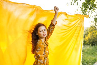 Elleri havada neşeli bir kadın poz veriyor.