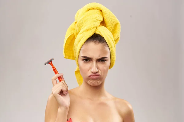 Bela mulher com uma toalha amarela em sua cabeça de barbear — Fotografia de Stock