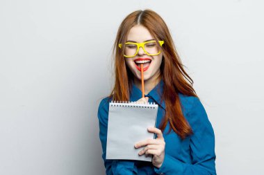 Not defteri ve kalem takan, sarı gözlüklü profesyonel bir iş kadını.