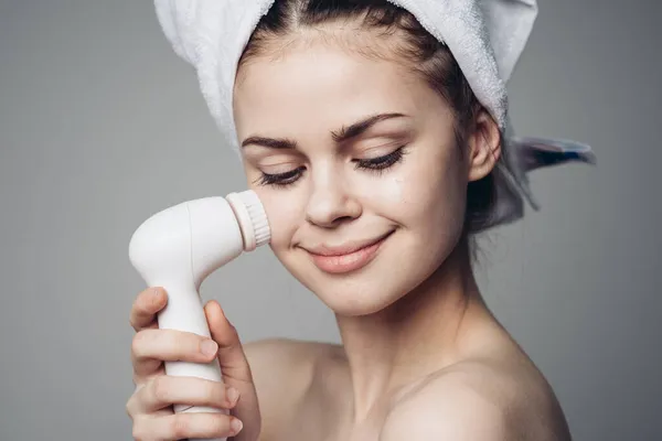 Woman with towel on head facial massager skin care hygiene — Stock Photo, Image