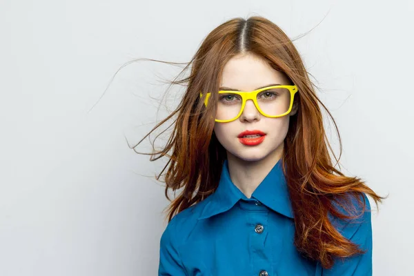 黄色のメガネの感情を身に着けている青いシャツのビジネス女性 — ストック写真