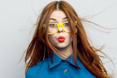 Sarı gözlüklü, mavi gömlekli neşeli ulusal kadın.