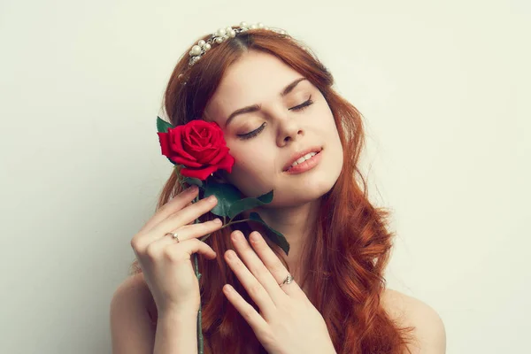 Hermosa mujer con el pelo rojo rosa roja flor de cerca — Foto de Stock
