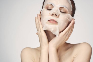 Güzel bir kadın çıplak omuzlarıyla maske takar.