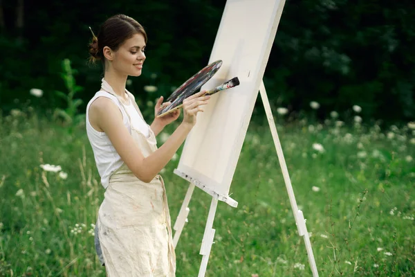 Žena umělec s paletou barev kreslení stojan příroda koníček — Stock fotografie