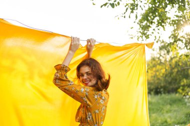 Kadın, doğaya poz veriyor, sarı kumaş temiz hava.