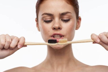 Çıplak omuzlu, neşeli bir kadın diş fırçası, diş fırçası, ağız bakımı.