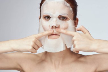 Çıplak omuzlu kadın maske takıyor.