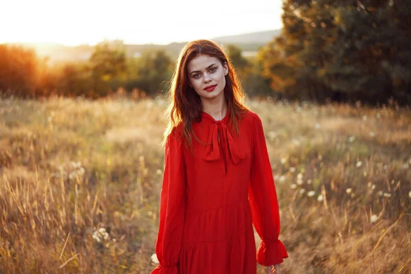 Femme en robe rouge dans un champ dans la nature été paysage liberté — Photo