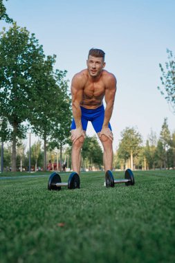 Parktaki sportif adam Crossfit egzersizi yapıyor.