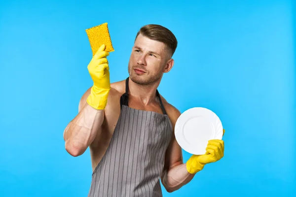 Homem em avental limpeza louça lavagem azul fundo — Fotografia de Stock