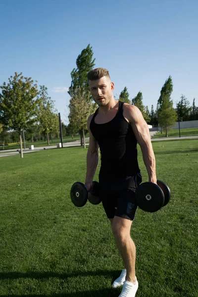 Hombre atlético bombeado cuerpo en el ejercicio del parque fitness aire libre —  Fotos de Stock