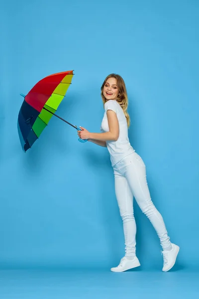 Femme à la mode avec des couleurs parapluie arc-en-ciel posant fond bleu — Photo