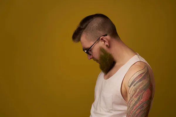 Homem em uma t-shirt branca tatuagens em seus braços moda óculos estilo moderno — Fotografia de Stock