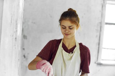Beyaz önlüklü ev dekorasyonu yapan neşeli kadın ressam.