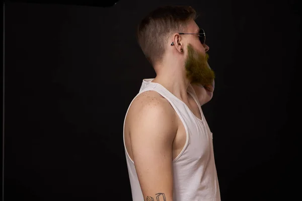 Hombre barbudo en camiseta blanca con tatuajes en sus brazos posando bravucón — Foto de Stock