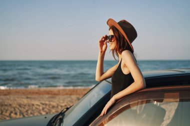Kadın plajda araba yolculuğunun yanında yaz tatili