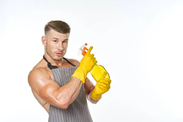 Homem alegre em avental detergente posando músculos — Fotografia de Stock