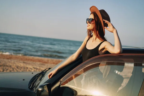 ผู้หญิงสวยในแว่นตากันแดด ใกล้รถในไลฟ์สไตล์การเดินทางชายหาด — ภาพถ่ายสต็อก