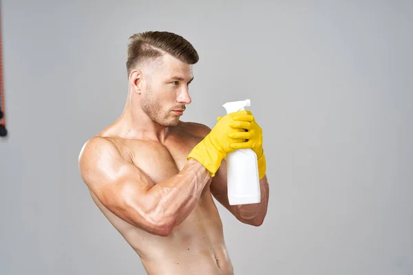 Hombre con músculos bombeados detergente posando limpieza —  Fotos de Stock