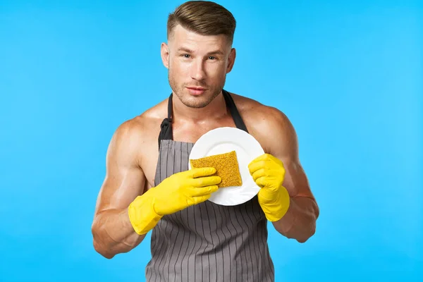 围裙清洁洗碗蓝色背景的男人 — 图库照片