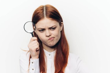 Yüzünde büyüteçle yüzünü buruşturan güzel bir kadın.