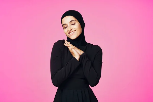 Glad muslimsk kvinna i svart hijab poserar mode rosa bakgrund — Stockfoto