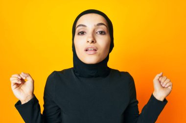 Siyah tesettürlü neşeli kadın moda eli pozu veriyor stüdyo hayatı tarzında.