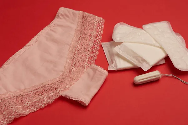 Almofadas tampões roupa interior feminino higiene vermelho fundo — Fotografia de Stock