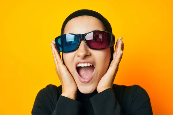 Muselman i svart hijab popcorn 3D glasögon bio gul bakgrund — Stockfoto