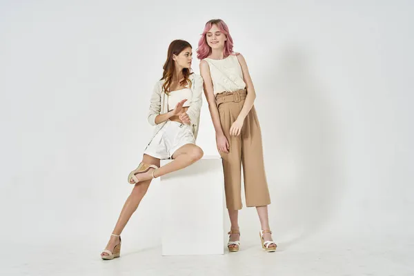 Duas mulheres na moda roupas posando modelo decoração — Fotografia de Stock