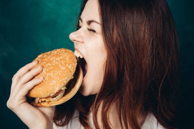 Hamburger yiyen bir kadın.