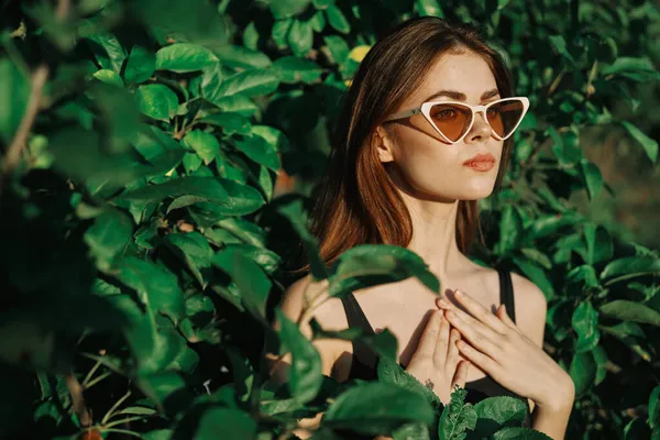 Sonriente mujer usando gafas de sol verde hojas naturaleza moda — Foto de Stock