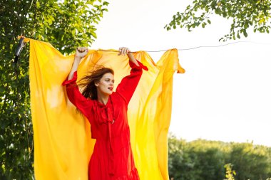 Kırmızı elbiseli duygusal kadın. Sarı arka plan pozu.