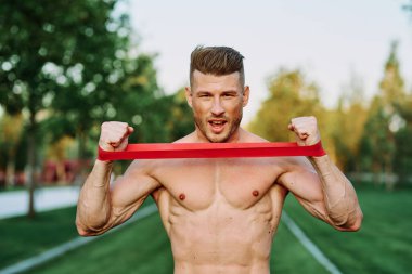Parkın spor salonunda şişkin vücutlu atletik bir adam.